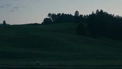 Blue Hour Landscape Featuring Rolling Green Hills and a Crescent Moon Stock Footage 331164172
