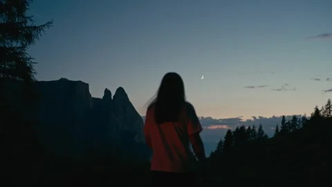 Blue Hour over the Mountains with a Crescent Moon and Silhouetted Person 库存影片 331164191