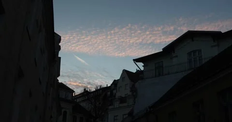 Blue hour rooftops under pink altocumulus, old town silhouette Stock Footage 320168808