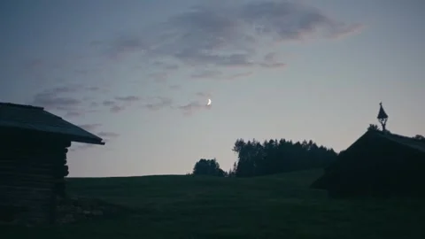 Blue Hour Twilight Landscape Featuring a Moonlit Alpine Meadow and Huts 库存影片 331164233
