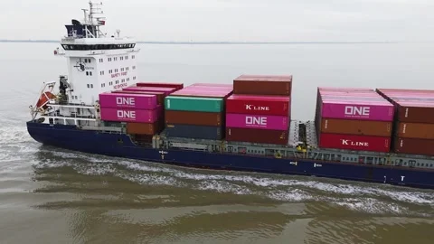 Blue hulled container ship sails smoothly across calm coastal waters stacked Stock Footage 328200850