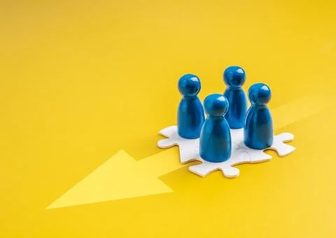 Blue human figures on puzzle pieces, forward arrow represent teamwork, stak.. Stock Photos