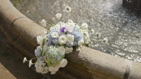 Blue Hydrangea And White Rose Arrangement On A Stone Fountain Edge 스톡 동영상 343803076