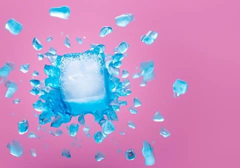 Blue ice block exploding into shards on pink pastel background Stock Photos