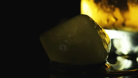 Blue ice cubes on a dark background illuminated by a bright lamp Stock Footage 136176008