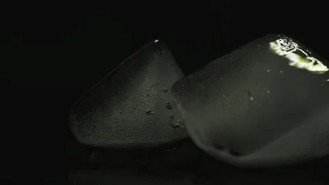 Blue ice cubes spin and move against a dark background Stock Footage 136175865