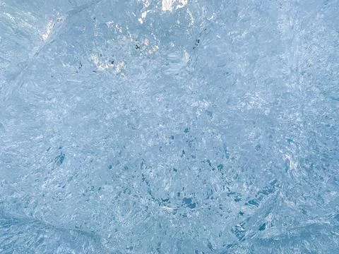 Blue ice with transparent elements and turquoise shadows. Stock Photos