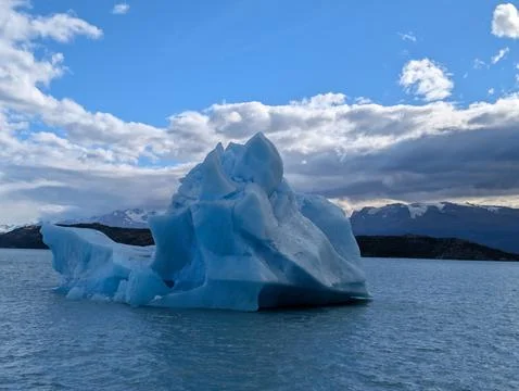 Blue Iceberg Beneath Dramatic Clouds in Canal Upsala Stock-Fotos