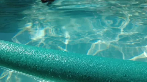 Blue inflatable floating in a pool on a sunny day 스톡 동영상 245063497
