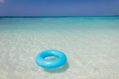 Blue inflatable ring floating in tropical ocean Foto stock