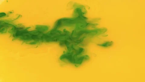 Blue ink dropping in yellow ink to create a green splat. Vibrant and vivid Video stock 72285552