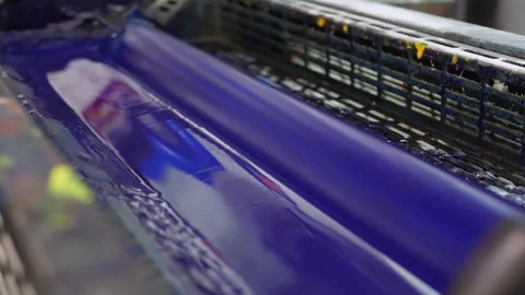 Blue ink rollers inside offset printing press distributing pigment Stock Footage 321540031