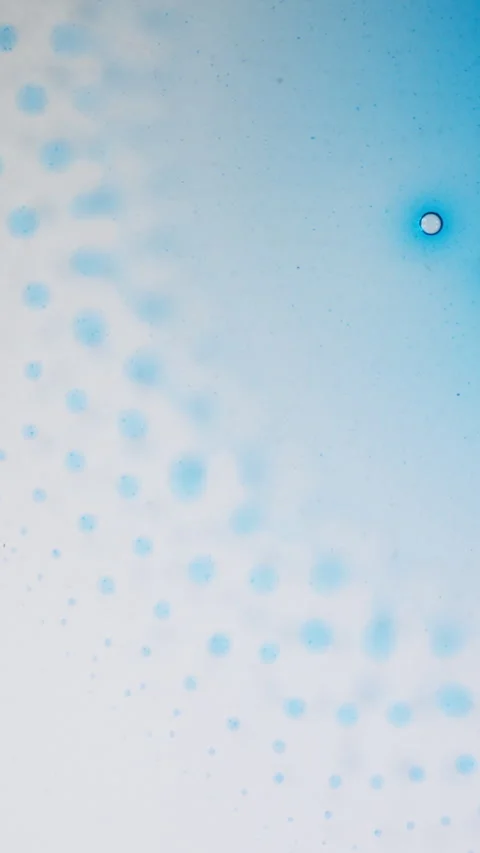 Blue Ink Spreading and Forming Cell-Like Patterns in Liquid, Vertical Macro Stock Footage 340883745