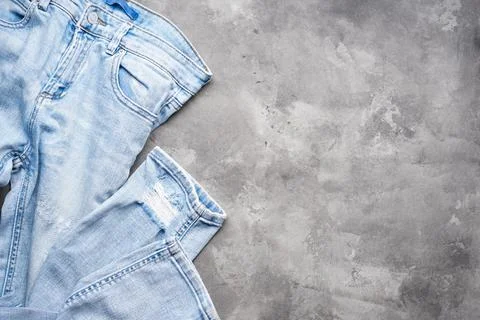Blue jeans on a gray background, space for text. Top view. Stock Photos