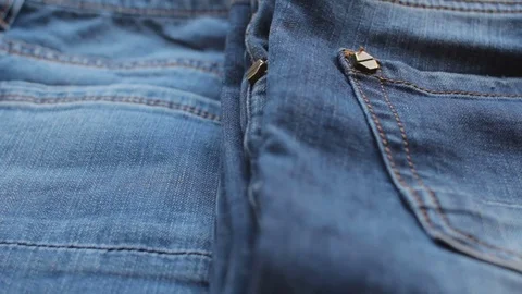 Blue jeans lying on a shelf in a store. Closeup Stock Footage 73610250