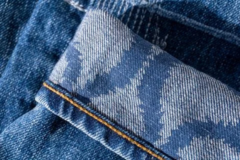 Blue jeans with patterns on the cuffs and decorative seams close up Stock Photos