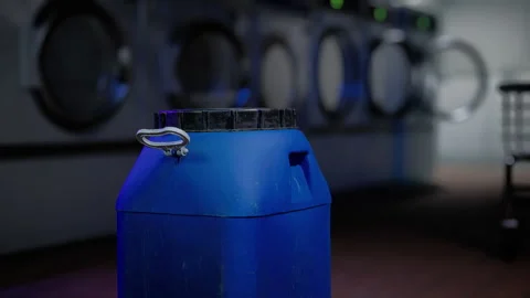 A blue jug sitting in front of a stack of dryers Stock Footage 266141999