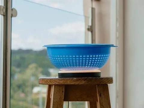 Blue kitchen drainer on stool with window and blur background Stock Photos
