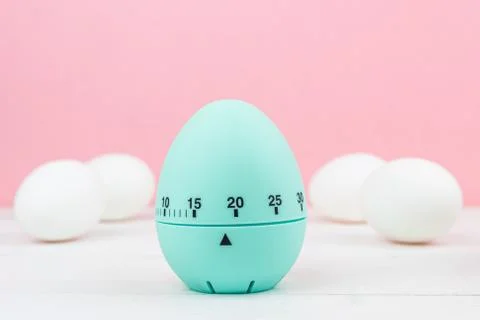 Blue kitchen egg timer on a pink background. cooking time, soon Easter Stock Photos