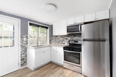A blue kitchen with white cabinets. Stock Photos