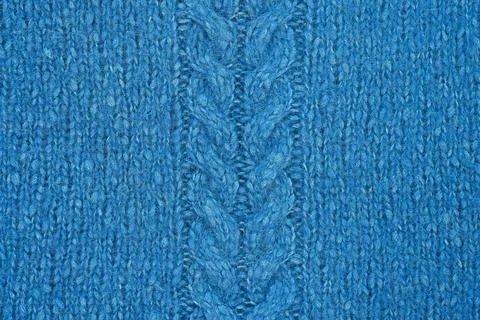 Blue knitted texture with a relief pattern in the middle. Handmade Knitwear. Stock Photos