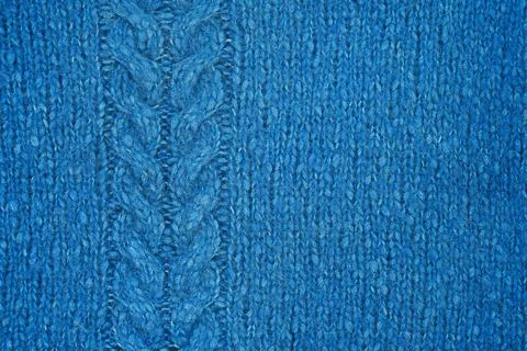 Blue knitted texture with a relief pattern. Handmade Knitwear. Stock Photos
