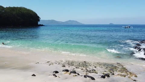 Blue Lagoon Beach Padangbai White Sand Waves Snorkeler and Traditional Boat Stock Footage 339751676