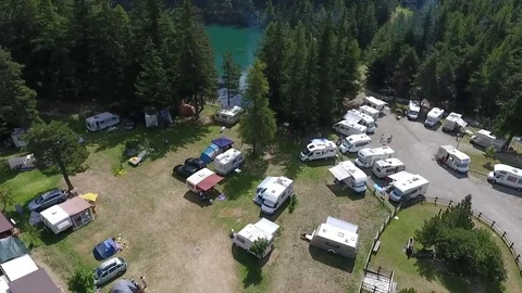 Blue lake at the edge of a campsite Stock Footage