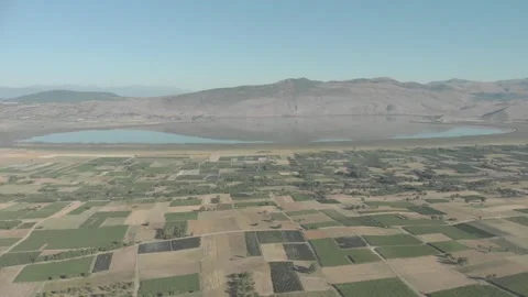 Blue lake with reflection under blue sky and mountain, fields and farms 库存影片 196613651