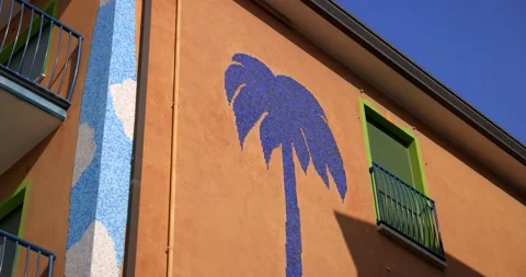 Blue large palm tree painted on an orange block of flats design Stock Footage 150154375