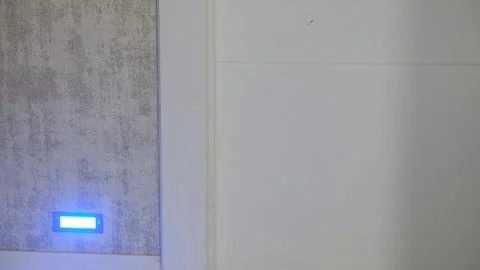 Blue LED Light Glowing on Wallpapered Wall in Cozy Home Interior Stock Footage 304297553