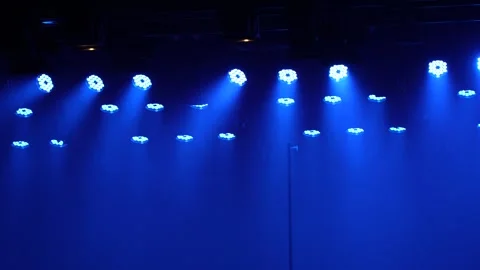 Blue LED stage lights emitting bright beams through smoke Stock Footage 346360897