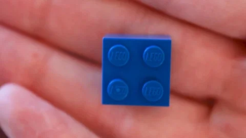 Blue LEGO Brick in Hand Video stock 116118977