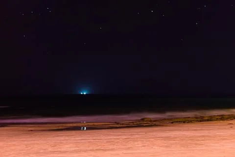 Blue light and his reflection in the middle of the sea, by night Stock Photos