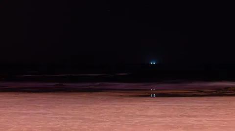 Blue light and his reflection in the middle of the sea, by night Stock Photos