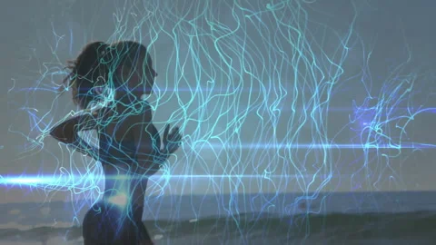 Blue light cascade drifting above beach and female runner jogging through Видео 313494488