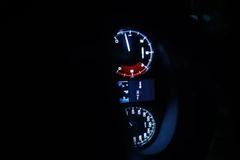 Blue light cast of a car speedometer at night 库存照片