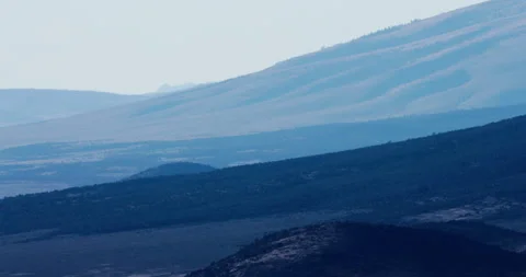 Blue light over mountain silhouettes &amp; dust cloud, abstract, Southwest, 4K Stock Footage 250415301