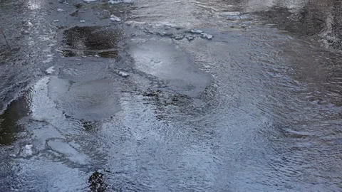 Blue light reflected on partially frozen winter stream Stock Footage 297257641
