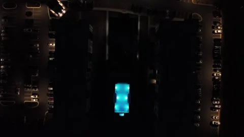 Blue lighting community swimming pool In luxury condos apartment neighborhood Stock Footage 318160754