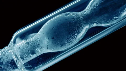 Blue liquid condensing on bulb lab condenser black background Stock Footage 335281106