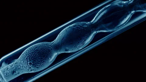 Blue liquid condensing on bulb lab condenser black background Stock Footage 337110353
