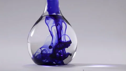 Blue liquid going down throughout water on a flat bottomed flask Stock Footage 231488194