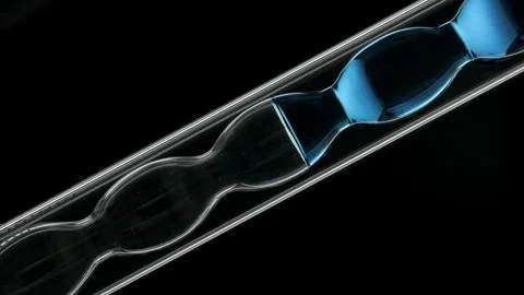 Blue liquid inside inclined bulb lab condenser black background Stock Footage 337759389