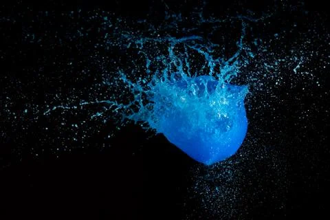 Blue liquid paint exploding with black background Stock Photos