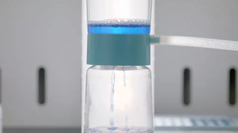 Blue liquid poured into a filter in a pharmaceutical research laboratory Stock Footage 274350933