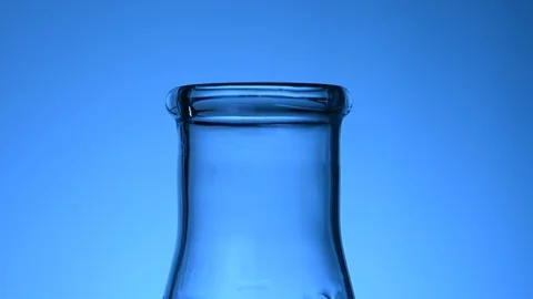 Blue liquid is poured into a flask in a laboratory Stock Footage 121634729