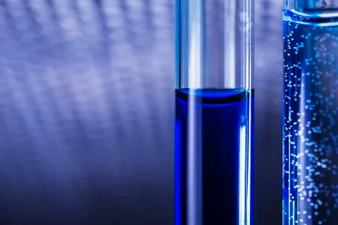Blue liquid in tubes on blured medical background Stock Photos