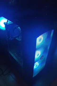 Blue-lit gaming pc case with front mesh panel Stock Photos