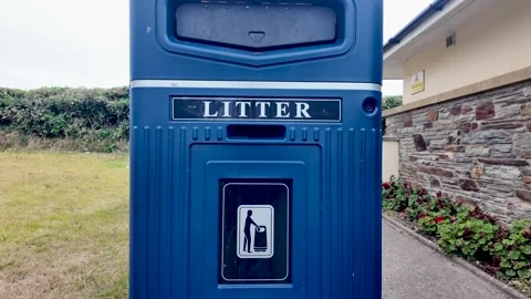 Blue Litter Bin In Park Setting With Building, Grass And Shrubs 動画素材 332707704